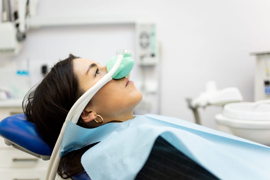Patient wearing a nitrous oxide nasal mask in the dental chair