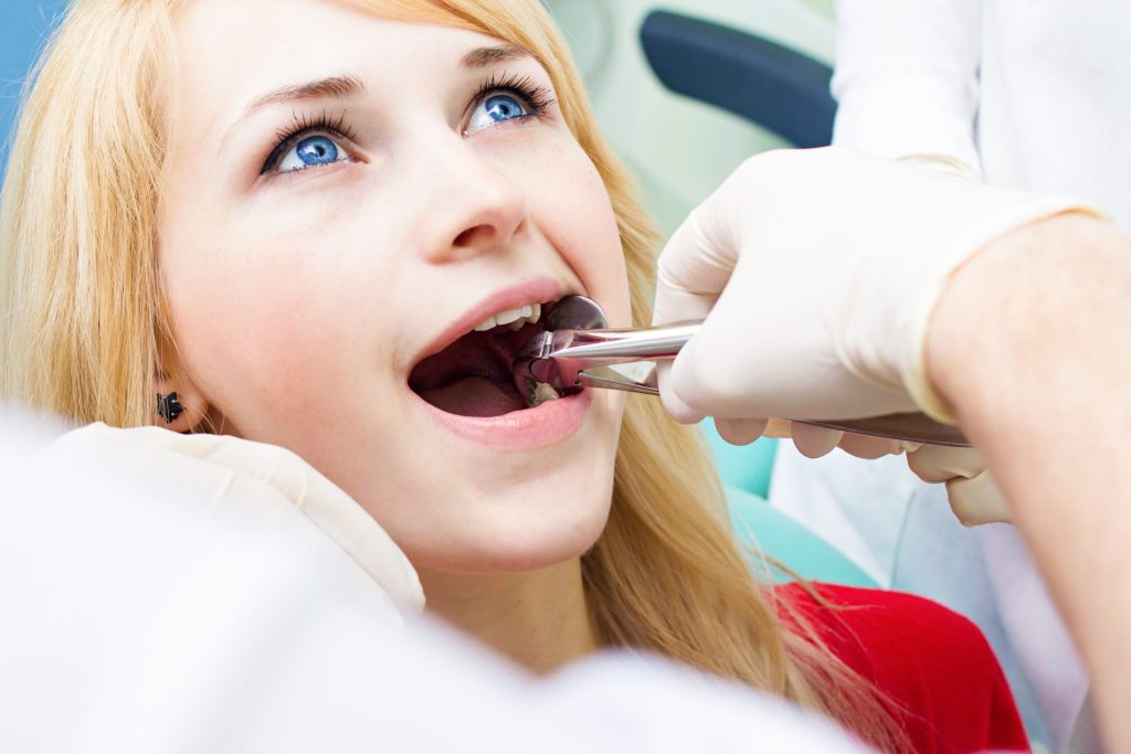 Dentist gently extracting a tooth