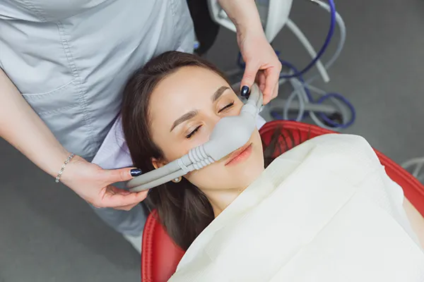 Patient relaxing with a nitrous oxide nasal mask in the dental chair